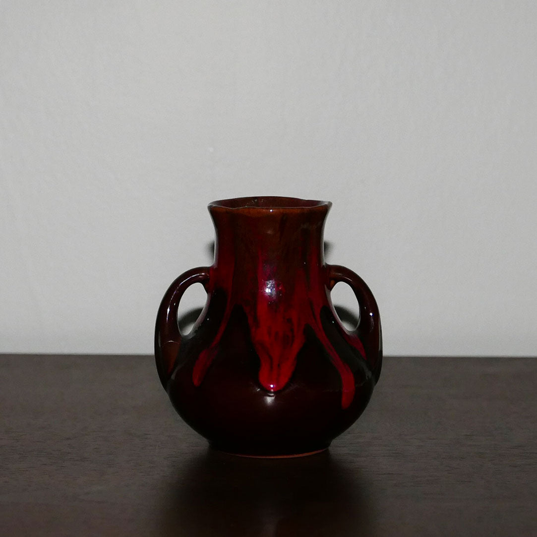 small mcm vase with handles featuring drip glaze design in warm red and brown tones.