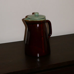 mid-century pitcher in brown & teal featuring glazed finish, handle, lid, and round base.